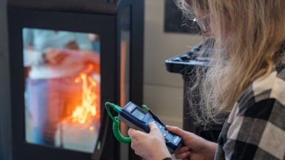 Elev måler temperaturen på røykgassen med et instrument